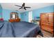 Bedroom with a ceiling fan, wood-look floors, dresser, and a TV at 16011 Saddle Creek Dr, Tampa, FL 33618