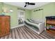Green bedroom with wood-look flooring, daybed, and side table at 16011 Saddle Creek Dr, Tampa, FL 33618