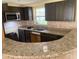 Modern kitchen with granite countertops, dark cabinets, and stainless steel appliances at 17220 Estes Rd, Lutz, FL 33548