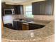 Kitchen featuring granite countertops, dark cabinetry, and stainless steel microwave at 17220 Estes Rd, Lutz, FL 33548