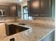 Modern kitchen with granite countertops, dark cabinets, and stainless steel appliances at 17220 Estes Rd, Lutz, FL 33548