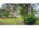 Lush backyard featuring a well-maintained lawn, mature trees, and garden beds at 1735 Cleveland St, Clearwater, FL 33755