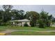 Single-story home featuring a well-manicured lawn and mature trees at 1735 Cleveland St, Clearwater, FL 33755