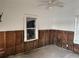 A bedroom with damaged walls and a ceiling fan, showing a room that needs extensive renovation at 2011 Oakwood Ave, Tampa, FL 33605