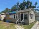 Exterior view of a modest home with a black door and needing some repairs and updates at 2011 Oakwood Ave, Tampa, FL 33605