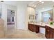 Beautiful bathroom with dual sinks, wood cabinets, tile flooring, and lots of natural light at 23325 Abercorn Ln, Land O Lakes, FL 34639