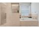 Elegant bathroom featuring a glass-enclosed shower, soaking tub, and tiled accents at 23325 Abercorn Ln, Land O Lakes, FL 34639