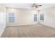 Spacious bedroom with carpet, three windows, and a ceiling fan at 23325 Abercorn Ln, Land O Lakes, FL 34639