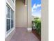 Covered entryway featuring brick pavers, white trim, and views of manicured landscaping at 23325 Abercorn Ln, Land O Lakes, FL 34639