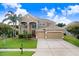 Stunning two-story home featuring a manicured lawn, mature trees, and a convenient two-car garage at 23325 Abercorn Ln, Land O Lakes, FL 34639