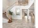 Bright, spacious foyer with tile floors, a curved staircase, and an elegant chandelier at 23325 Abercorn Ln, Land O Lakes, FL 34639