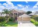 Attractive two-story home featuring a three-car garage, well-kept lawn, and mature landscaping at 23325 Abercorn Ln, Land O Lakes, FL 34639
