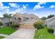 Beautiful home features a three-car garage, manicured lawn, and lovely landscaping at 23325 Abercorn Ln, Land O Lakes, FL 34639