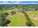 Scenic aerial view of the golf course with well-manicured greens and a beautiful clubhouse at 23325 Abercorn Ln, Land O Lakes, FL 34639