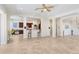 Open-concept living room and kitchen featuring tile floors, neutral walls, and abundant natural light at 23325 Abercorn Ln, Land O Lakes, FL 34639