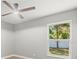 This bedroom has a ceiling fan and a bright window with a view of the backyard at 2433 Blind Pond Ave, Lutz, FL 33549