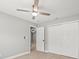 Light filled bedroom with wood-look tile floors, ceiling fan, and double door closet at 2433 Blind Pond Ave, Lutz, FL 33549