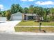 Well-maintained single Gathering home with a manicured lawn, mature trees, and an attached two-car garage at 2433 Blind Pond Ave, Lutz, FL 33549
