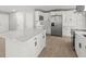Spacious kitchen with an island, stainless steel appliances, quartz countertops, and wood-look tile flooring at 2433 Blind Pond Ave, Lutz, FL 33549