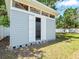 Charming backyard storage shed with an open shuttered door at 2433 Blind Pond Ave, Lutz, FL 33549