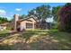 Backyard showing screened-in pool patio, neutral-colored home and large shade trees at 2903 Manor Ridge Pl, Valrico, FL 33596