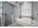 Elegant bathroom featuring a soaking tub, walk-in shower, and sleek tiling at 2903 Manor Ridge Pl, Valrico, FL 33596