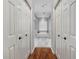 Hallway view leading to a bathroom with dual doors, hardwood floors, and a decorative aesthetic at 2903 Manor Ridge Pl, Valrico, FL 33596