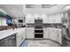 Modern kitchen with white cabinets, stone counter tops and stainless appliances at 2903 Manor Ridge Pl, Valrico, FL 33596