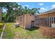 Backyard shed with wood door and window, exterior storage and lush landscaping at 2903 Manor Ridge Pl, Valrico, FL 33596