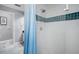 Shower stall with white-and-blue tiles and a curtain at 2903 Manor Ridge Pl, Valrico, FL 33596