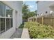Landscaped backyard with wood fence, green grass, and a small side patio at 307 S Arrawana Ave # 100, Tampa, FL 33609