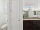Bright bathroom boasts a double vanity with granite counters, complemented by a toilet and white door at 307 S Arrawana Ave # 100, Tampa, FL 33609