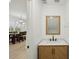 Elegant half bathroom featuring a stylish vanity and a wood-framed mirror at 307 S Arrawana Ave # 100, Tampa, FL 33609
