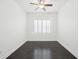 Inviting bedroom with dark wood floors, complemented by a modern ceiling fan and shuttered window at 307 S Arrawana Ave # 100, Tampa, FL 33609