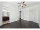 Bedroom showcasing dark wood floors and a ceiling fan, with an open doorway view of the bathroom at 307 S Arrawana Ave # 100, Tampa, FL 33609
