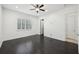 Spacious bedroom with dark hardwood floors, ceiling fan, and natural light from shuttered windows at 307 S Arrawana Ave # 100, Tampa, FL 33609