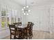 Charming dining room featuring shuttered windows, wood table with seating for six and modern chandelier at 307 S Arrawana Ave # 100, Tampa, FL 33609