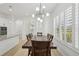 Formal dining room boasts a long table with seating for six, chandelier, and natural light through shuttered windows at 307 S Arrawana Ave # 100, Tampa, FL 33609