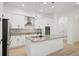 Modern kitchen with an island, stainless steel appliances, white cabinets, and stone backsplash at 307 S Arrawana Ave # 100, Tampa, FL 33609