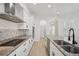 Modern kitchen featuring stainless steel appliances, granite countertops, a range hood, and white cabinetry at 307 S Arrawana Ave # 100, Tampa, FL 33609