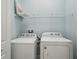 Bright laundry room with white washer and dryer and wire shelving for storage at 307 S Arrawana Ave # 100, Tampa, FL 33609