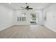 Bright, airy living room with light wood floors, ceiling fan, and sliding glass doors to the backyard at 307 S Arrawana Ave # 100, Tampa, FL 33609
