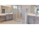 Elegant bathroom with dual vanities, a glass-enclosed shower, and contemporary tile at 3206 Lumber Falls Dr, Plant City, FL 33565