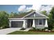 Charming single-story home with blue siding, a gray roof, a two-car garage and a manicured lawn at 3206 Lumber Falls Dr, Plant City, FL 33565