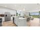 Open-concept kitchen with stainless steel appliances, large island, and seamless flow to the dining area at 3404 Lumber Falls Dr, Plant City, FL 33565