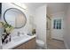 Well-lit bathroom featuring vanity with modern fixtures, toilet, and glass-enclosed shower at 35 Deerpath Dr, Oldsmar, FL 34677