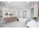 Modern bathroom featuring double vanity, soaking tub, and marble tile at 35 Deerpath Dr, Oldsmar, FL 34677
