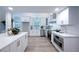 Bright kitchen with white cabinets, stainless steel appliances, quartz countertops, and modern fixtures at 35 Deerpath Dr, Oldsmar, FL 34677