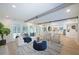 Bright and airy living room featuring hardwood floors, exposed beam ceiling, and access to the outdoor pool area at 35 Deerpath Dr, Oldsmar, FL 34677