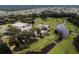Aerial view featuring the golf course, clubhouse, and maintenance buildings surrounded by mature trees at 36901 Tara Ave, Zephyrhills, FL 33542